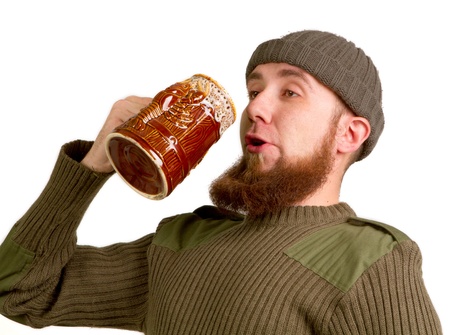 Happy young, bearded guy drinking beer from the glass on a white background