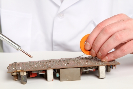 working electronics repairing board using soldering pen on a light backgroundの写真素材