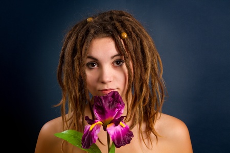 portrait of a beautiful young woman with dreadlocks against a dark background
