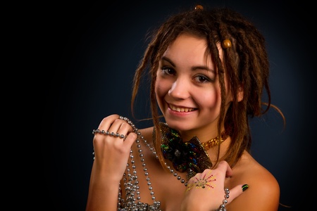 portrait of a beautiful young woman with dreadlocks against a dark backgroundの写真素材
