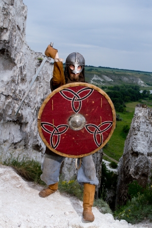 Knight  on a rock with a sword against blue cloudy skyの写真素材