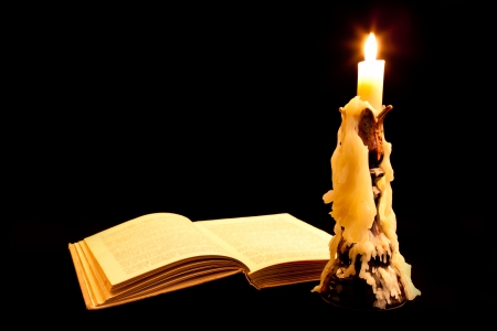 Old book and candle on dark backgroundの写真素材