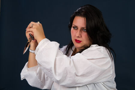 young beautiful brunette in a white shirt on a dark backgroundの写真素材