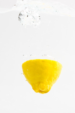 Lemon with water splash on a white backgroundの写真素材