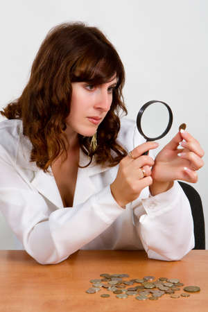 Financial concept, hand hold magnifying glass and coinsの写真素材