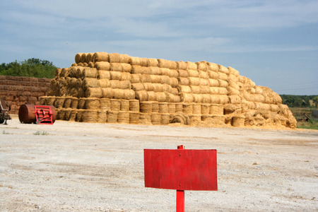 A pyramid of hay with the blue cloudy sky in the backgroundの写真素材