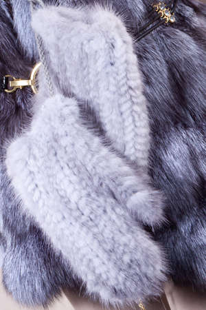 gray knitted mittens on a background of fur winter clothingの写真素材