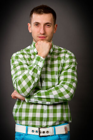 young guy in a checkered shirt on a gray backgroundの写真素材