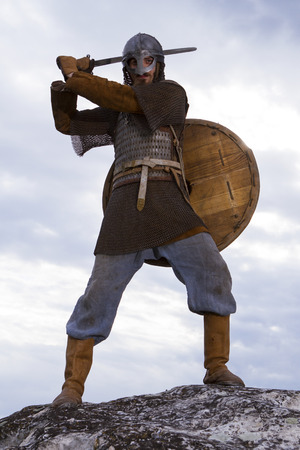 Knight  on a rock with a sword against blue cloudy skyの写真素材