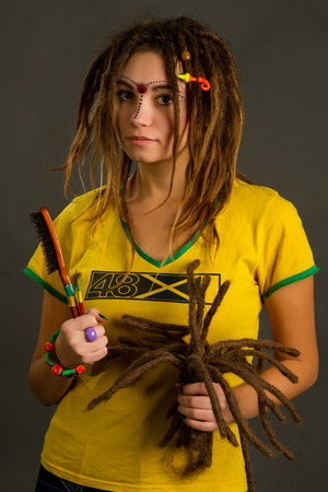 portrait of a beautiful young woman with dreadlocks  on a gray backgroundの写真素材