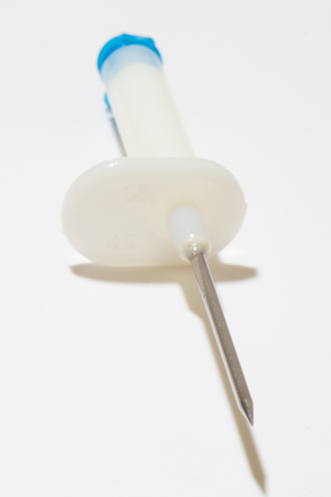 Medical drip from the needle  isolated on whiteの写真素材