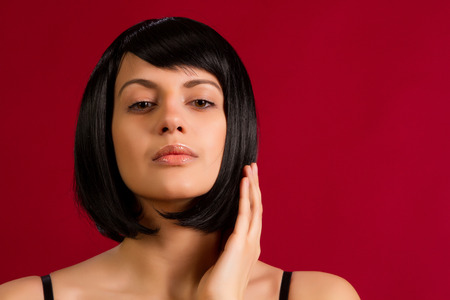 Portrait of sexy brunette on red background in studioの写真素材