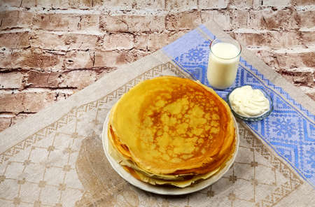 A stack of pancakes with sour cream and milkの写真素材