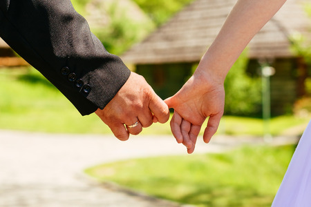 Closeup Hands of a Couple Held Together oToned Photo with Shallow Depth of Field. Focus on Ring.の写真素材