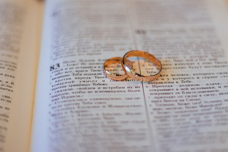 Two wedding rings on a bible bible wedding ringsの写真素材