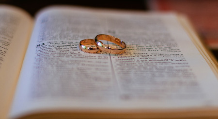 Two wedding rings on a bible bible wedding ringsの写真素材