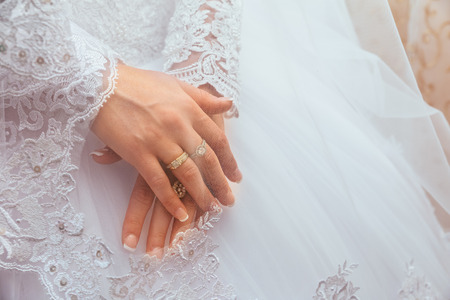 Lace white wedding dress with long sleeves. Women's hands. wedding ringの写真素材