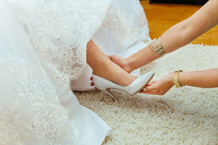 Wedding preparation. Girlfriends of the bride help her in my shoes marriage shoesの写真素材