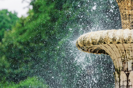 Water fountain in park. Splashing streams of fountain in Water stream pouring from fountain. Fountain water splashing on water surface of park lake. Fountain in summer park.の写真素材