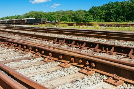 railway goes to horizon in green landscape sky clouds railroad treesの写真素材