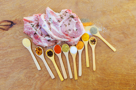 Raw pork chop steaks with meat fork, oil and spices for grill or cooking on rustic metal background, top view, border. Porco Iberico French Racks. pork steak spice to steakの写真素材