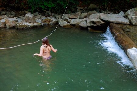 Close up warm portrait of beautiful ginger, beautiful girl floating in the riverの写真素材