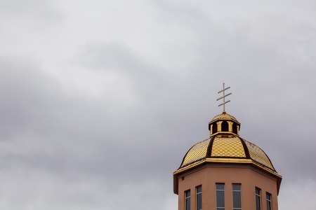 Golden dome of the Orthodox church on the blue sky background partially covered with snow.の写真素材