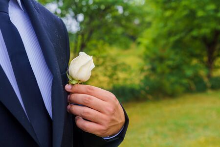 Wedding. The groom in a shirt and a waistcoat with a buttonhole is in the gardenの写真素材
