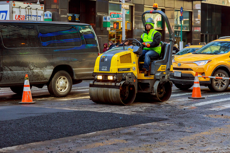 NEW YORK CITY - March 16, 2017: road under construction, asphalting in progress spring snowのeditorial素材