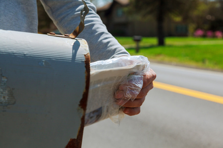Close-up Of Man's Hand Taking Letter From Mailbox Outside House Man takes mail from the mail boxの写真素材