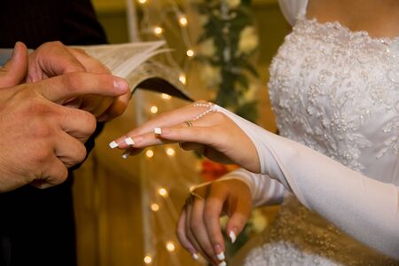 Groom putting a wedding ring on bride's finger bride groom wedding ringの写真素材