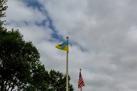 flags of the USA and Ukraine against bright blue sky Ukraine and USA flagsの写真素材