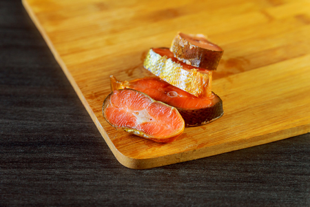 fresh raw salmon , red tuna , and sole fish pieces over wooden board