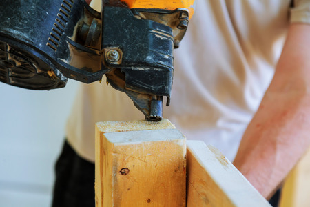 Gun construction shoot the nails in the wooden wallの写真素材