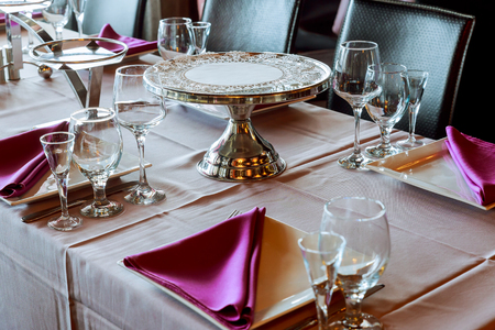 Serving table in restaurant with wine glasses and cutlery. Table served for wedding banquet. Table settingの写真素材