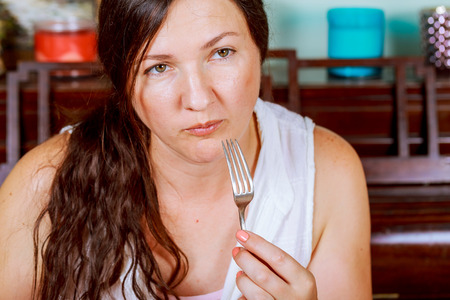 beautiful young woman eating in restaurantの写真素材