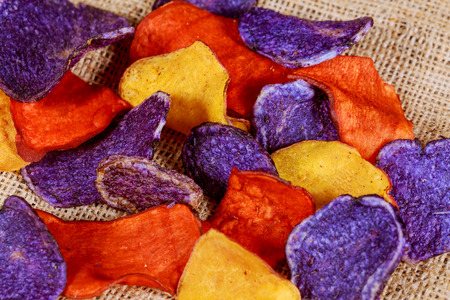 Beet and carrot salty chips in an old blue plate. wood backgroundの写真素材