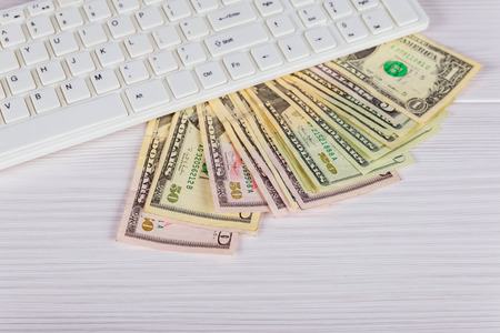 Working place of trader. The table covered by cash notes, keyboard and financial charts. Business financial working.の写真素材