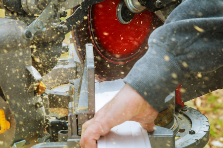 Man, worker sawing wood with a circular saw, machine for wood cutting. The manufacture of furniture. Furniture accessories. Machine for cutting MDF, particle Board.の写真素材