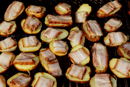 Big Slice Of Village-Style Potatoes On Hot BBQ Charcoal Grill. Flames of Fire In The Background. Tasty Snack For Outdoor Summer Barbecue Party Or Picnic.の写真素材
