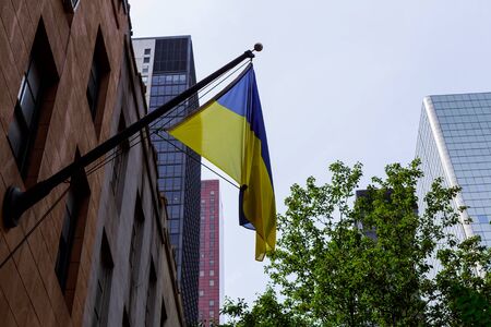 Ukrainian flag on the building Flag of Ukraine with a black mourning ribbon.の写真素材