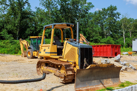 new construction tractor excavators and garbage containers waste in the container on construction