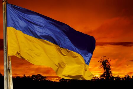 flag of ukraine against the background of the sunset in the glow of dawn greets the new day