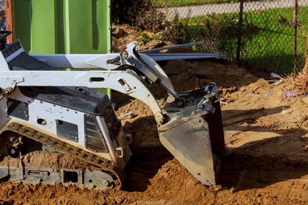 Earth moving by a bulldozer in the construction of small tractor on the structureの写真素材