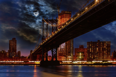 Manhattan Bridge illuminated at dusk very long exposure for a perfectly smooth waterの写真素材