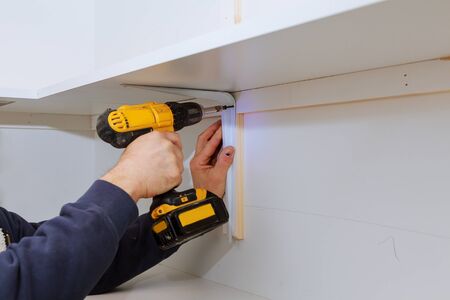 Man installing wooden shelves on brackets installation of shelvesの写真素材