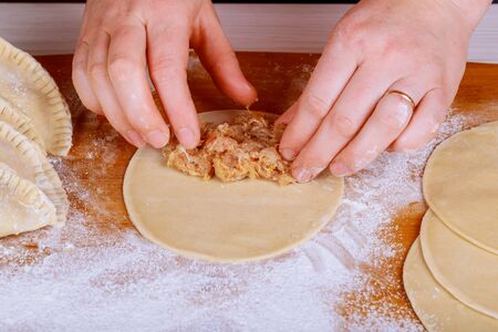 the cook makes cheburek with meat Chebureks, raw pasties with meat