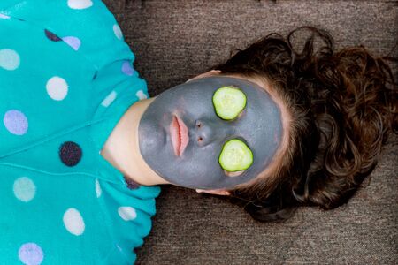 Spa Woman applying Facial cleansing Mask. Beauty Treatments mask on the face of a young girlの写真素材