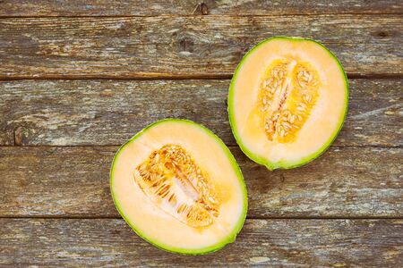 Melon slice on fresh honeydew melon on wooden table, healthy food.の写真素材