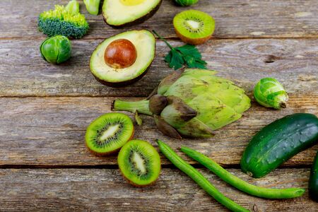 Green vegetables on wooden background peas, parsley, basil, cucumber, dill onion salad 
